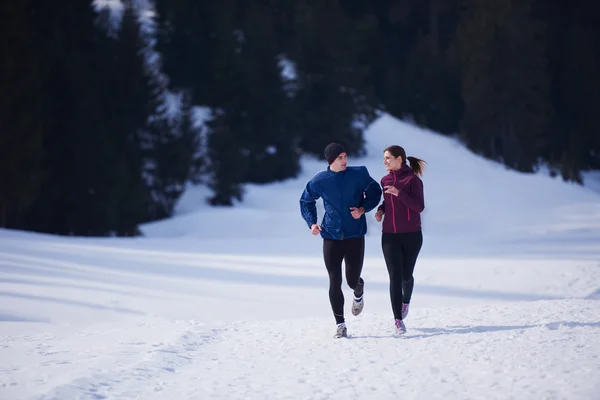 Paar joggt draußen auf Schnee — Stockfoto