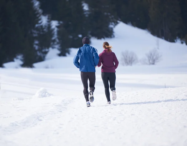 Paar joggt draußen auf Schnee — Stockfoto