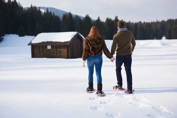 Casal se divertindo e andando em sapatos de neve — Fotografia de Stock