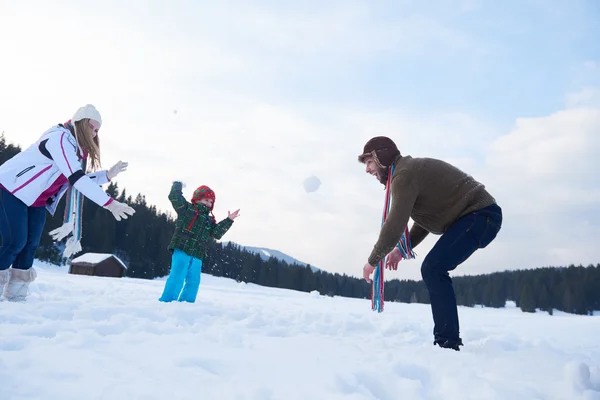 Glückliche Familie spielt im Winter zusammen im Schnee — Stockfoto