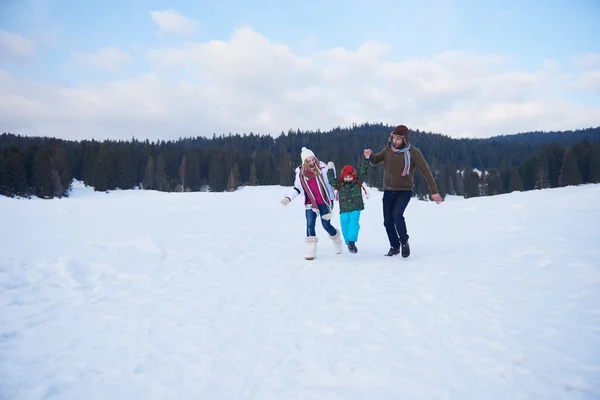 Família feliz brincando juntos na neve no inverno — Fotografia de Stock