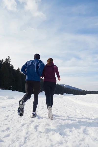 Paar joggt draußen auf Schnee — Stockfoto