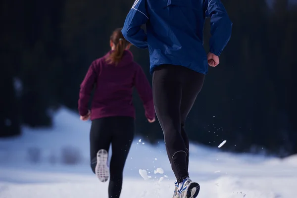 Paar joggt draußen auf Schnee — Stockfoto