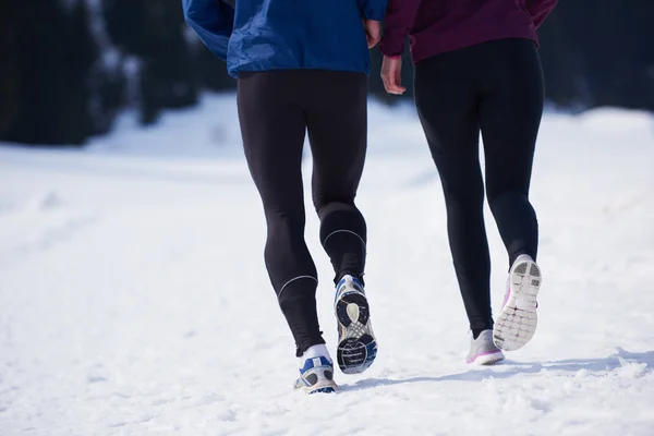 Paar joggt draußen auf Schnee — Stockfoto