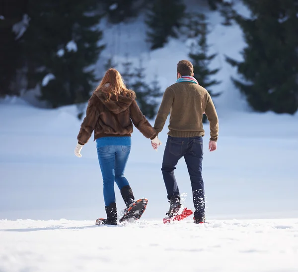 Casal se divertindo em sapatos de neve — Fotografia de Stock