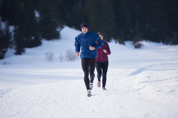 Paar joggt draußen auf Schnee — Stockfoto