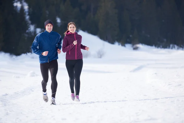 Paar joggt draußen auf Schnee — Stockfoto