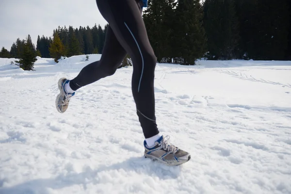 Homme jogging sur la neige dans la forêt — Photo