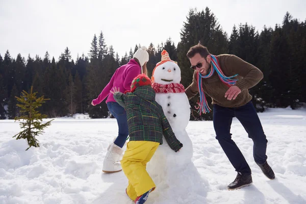 Happy family building snowman — Stock Photo, Image