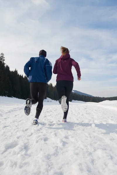 Paar joggt draußen auf Schnee — Stockfoto