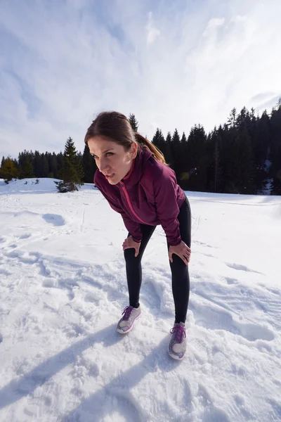 Yougn vrouw joggen buiten op sneeuw in bos — Stockfoto