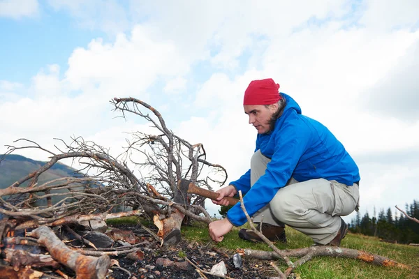 Hiking man try to light fire — Stock Photo, Image