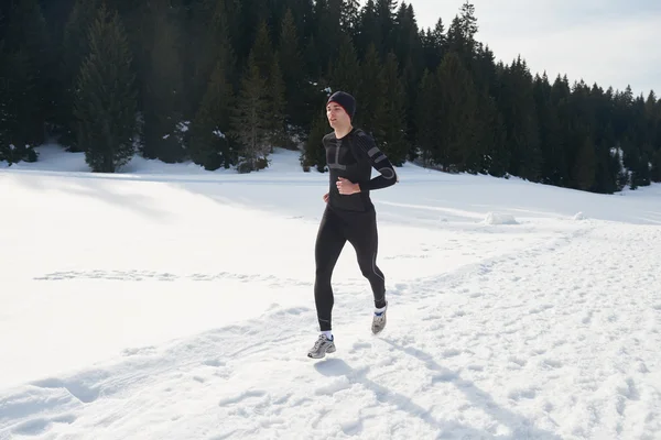 Man joggen op sneeuw in bos — Stockfoto