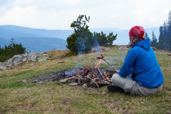 Hiking man prepare tasty sausages on campfire — Stock Photo, Image