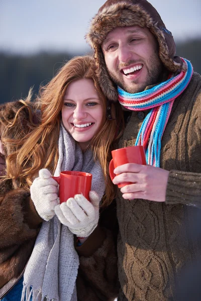 Feliz joven pareja bebiendo té caliente en invierno — Foto de Stock