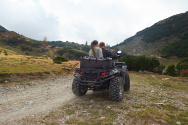couple driving atv quad bike