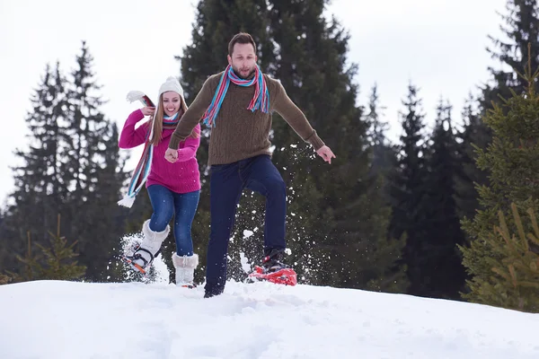 Couple having fun and walking in snow shoes — Stock Photo, Image