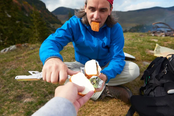 Caminhadas homem fatia saboroso queijo no piquenique — Fotografia de Stock