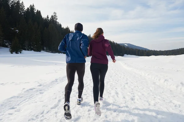 Paar joggt draußen auf Schnee — Stockfoto