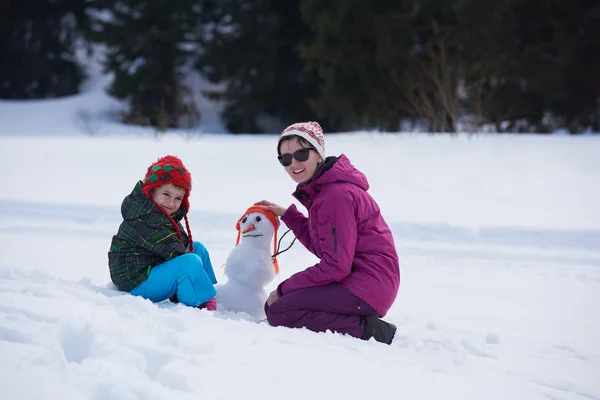 母と息子の雪だるまを構築 — ストック写真