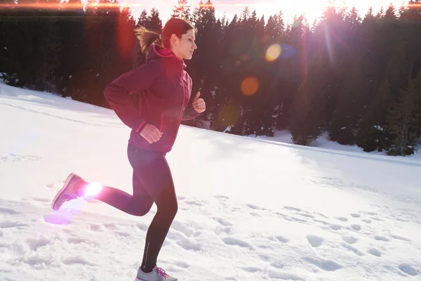 Fiatal nő a havat az erdőben kültéri jogging — Stock Fotó