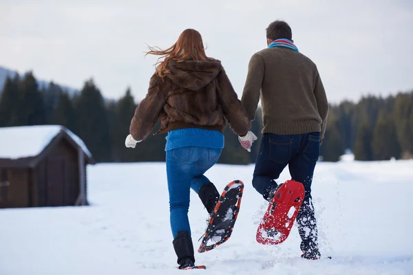 Pareja divirtiéndose en zapatos de nieve — Foto de Stock