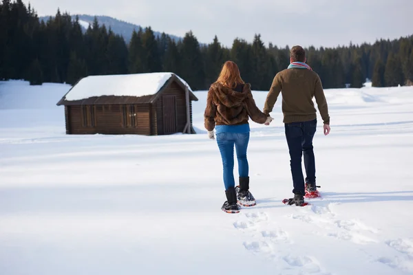 Casal se divertindo em sapatos de neve — Fotografia de Stock