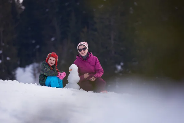 Madre e figlio costruzione pupazzo di neve — Foto Stock