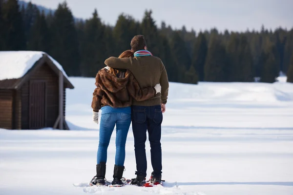 Casal se divertindo em sapatos de neve — Fotografia de Stock