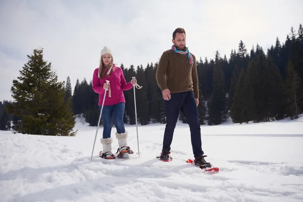 Couple having fun and walking in snow shoes — Stock Photo, Image