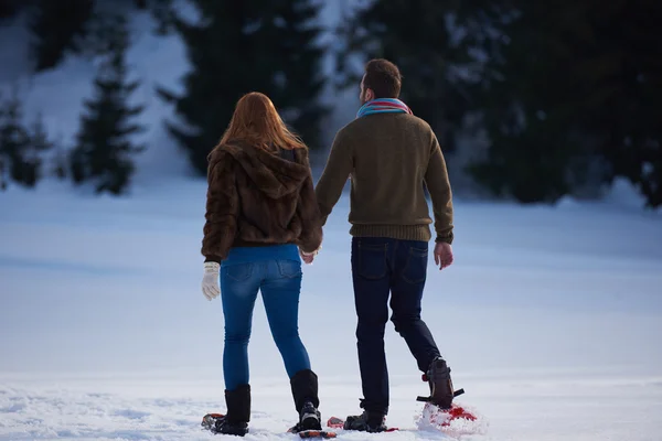 Casal se divertindo em sapatos de neve — Fotografia de Stock