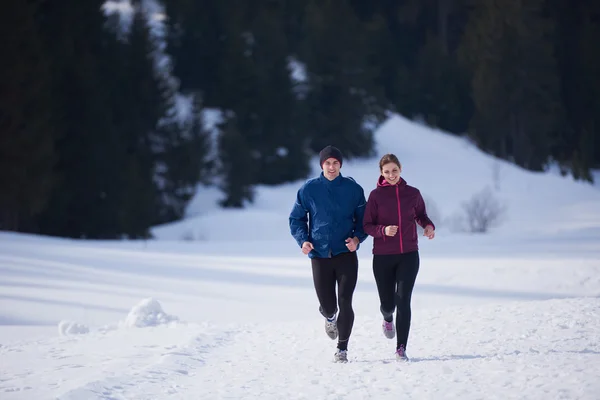 雪の上をジョギングするカップル — ストック写真