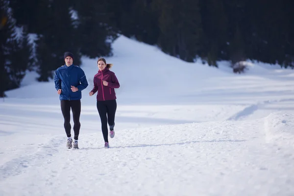 Paar joggt draußen auf Schnee — Stockfoto