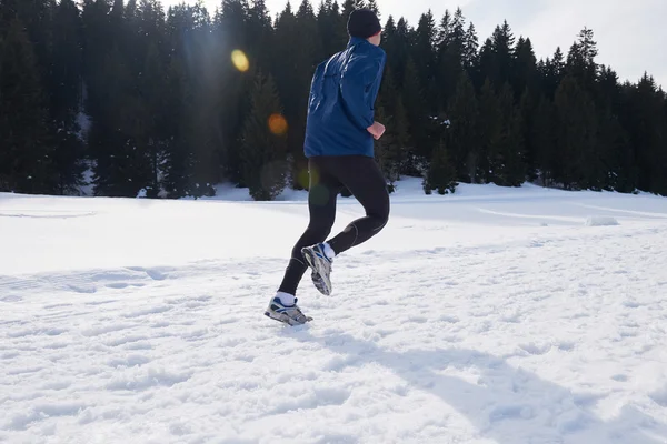 Homem correndo na neve na floresta — Fotografia de Stock