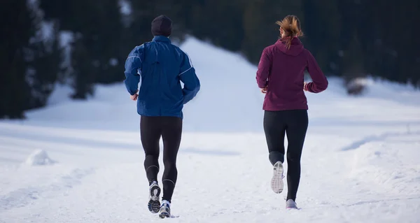 Paar joggt draußen auf Schnee — Stockfoto