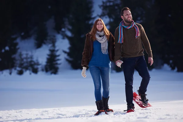 Casal se divertindo em sapatos de neve — Fotografia de Stock