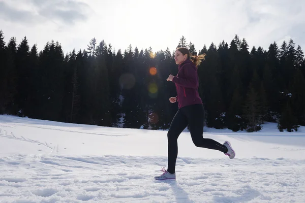 Fiatal nő a havat az erdőben kültéri jogging — Stock Fotó