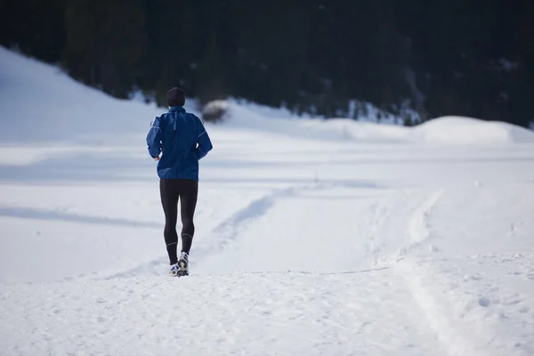 Homme jogging sur la neige dans la forêt — Photo