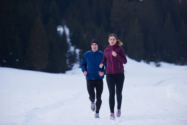 Paar joggt draußen auf Schnee — Stockfoto