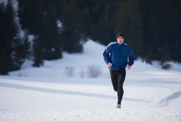 Homme jogging sur la neige dans la forêt — Photo