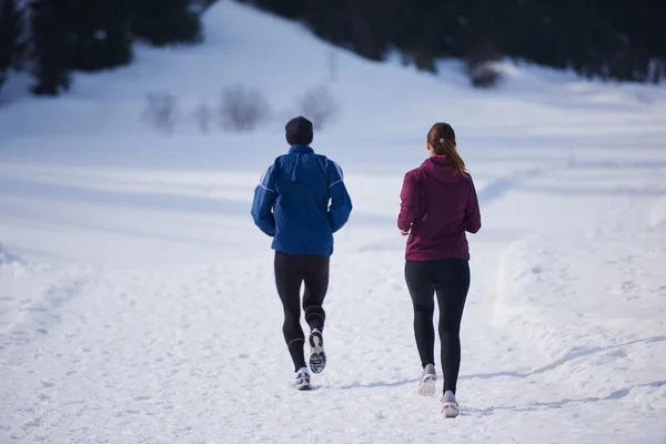 Paar joggt draußen auf Schnee — Stockfoto