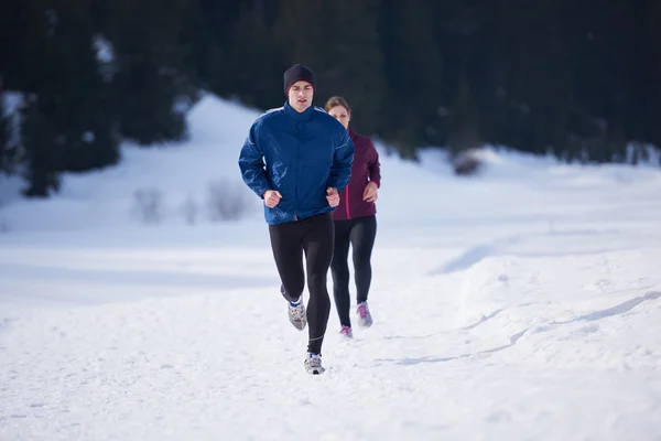 Paar joggt draußen auf Schnee — Stockfoto