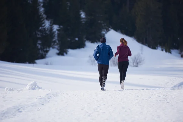 Paar joggt draußen auf Schnee — Stockfoto