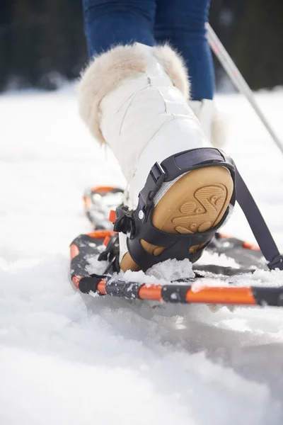 Mulher andando em sapatos de neve — Fotografia de Stock