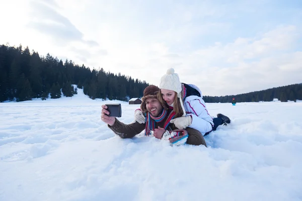 浪漫的夫妇在新鲜的雪, 并采取自拍 — 图库照片