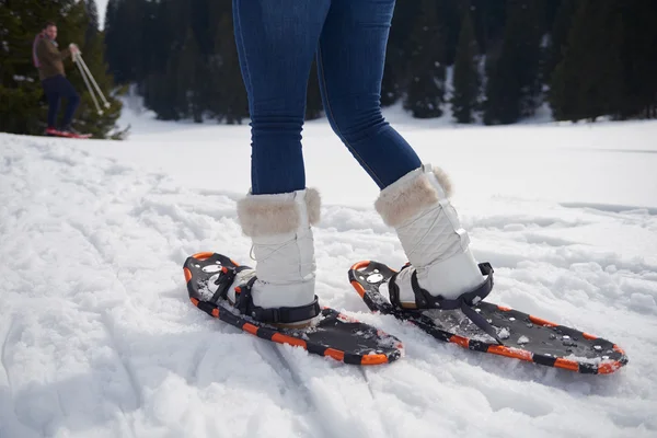 Frau läuft in Schneeschuhen — Stockfoto