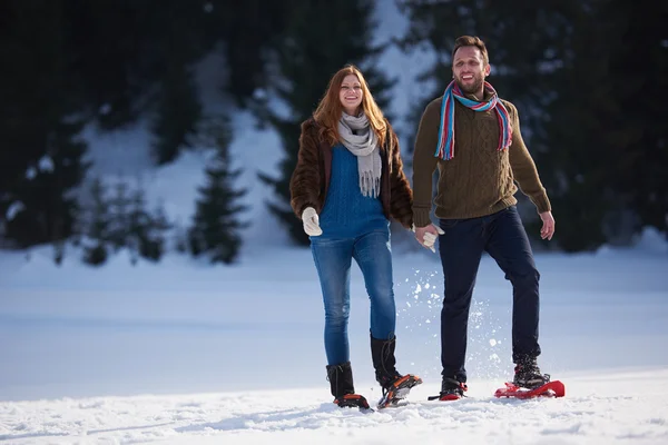 Casal se divertindo em sapatos de neve — Fotografia de Stock