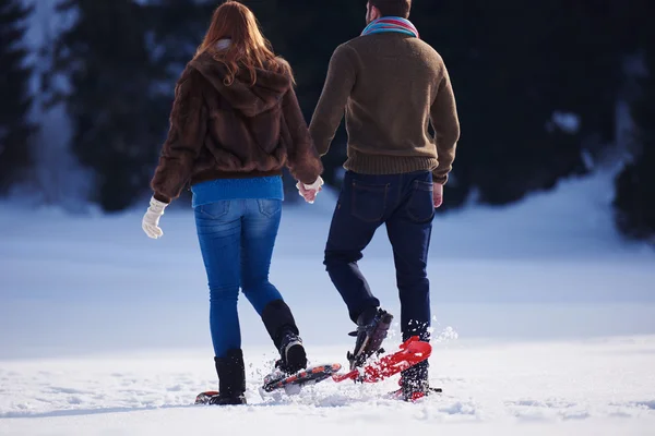 Casal se divertindo em sapatos de neve — Fotografia de Stock