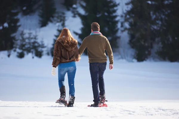 Casal se divertindo em sapatos de neve — Fotografia de Stock