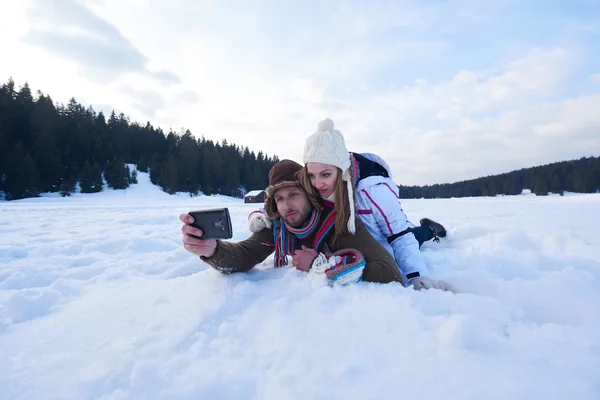 Romantikus pár a friss hó, és figyelembe selfie — Stock Fotó